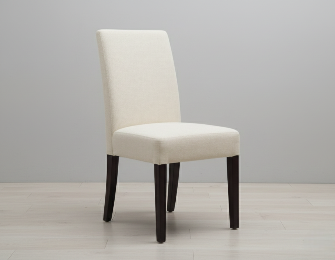 Modern cream upholstered dining chair Modern cream upholstered dining chair with high back and dark wood legs on a light wood floor.