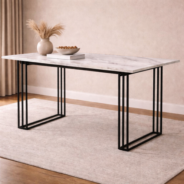 Marble top dining table with black metal grid frame legs, styled with a ceramic vase of pampas grass and a shallow bowl on a cream rug in a warm neutral dining room.