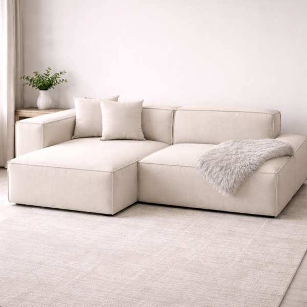 Cream L-shaped sectional sofa with low-profile modular design, plush linen upholstery, scatter cushions and a cozy grey throw, styled in a bright minimalist Japandi living room.