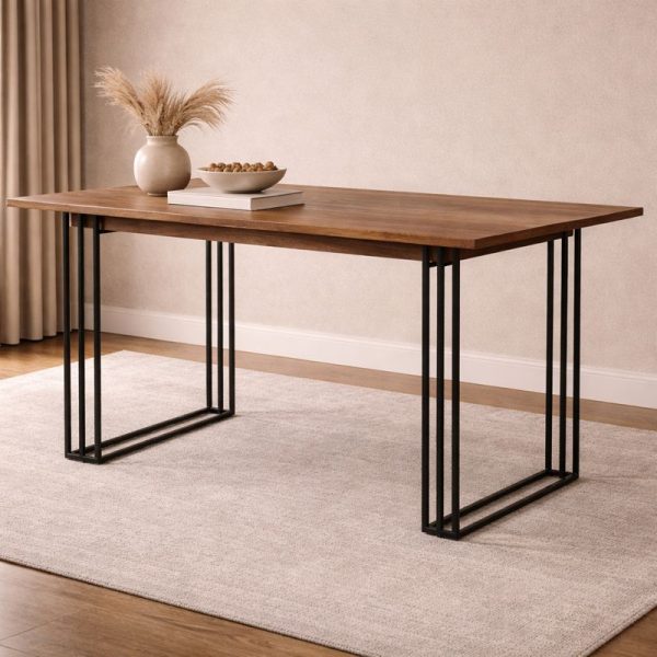 Walnut wood top dining table with black metal grid frame legs, decorated with pampas grass and a bowl on a light rug against a warm beige wall.