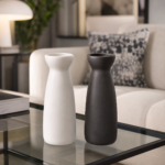 Minimalist ceramic vase in black and white color options on a glass coffee table in a modern living room.