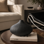 Black textured ceramic vase on a coffee table in a modern rustic living room.