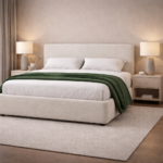 Cream upholstered bed with a curved headboard, soft fabric finish, white bedding, and modern bedside tables in a calm bedroom