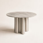 Modern round marble dining table with premium marble tabletop and stainless steel cylindrical pedestal base for contemporary dining rooms.