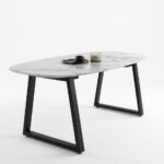 Corvo oval marble dining table with black trapezoid metal legs, angled view