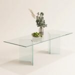 Vitra clear glass rectangular dining table with panel legs, styled with vase and fruit bowl