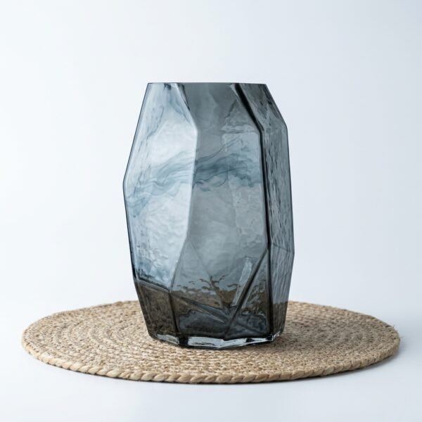 Onyx faceted smoked glass vase, front view on woven placemat