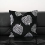 Maren black pumpkin motif cushion with white pumpkins on black leather sofa