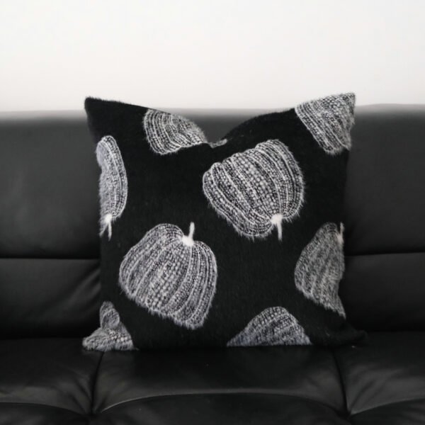 Maren black pumpkin motif cushion with white pumpkins on black leather sofa