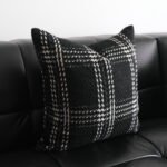 Onyx black and grey plaid cushion on black leather sofa