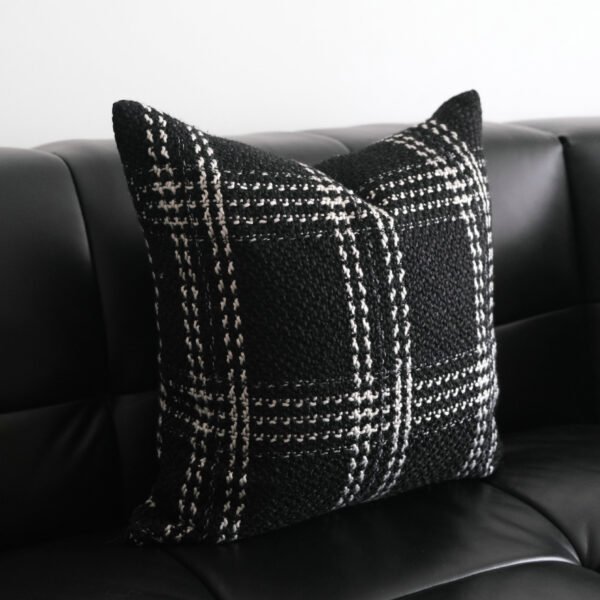 Onyx black and grey plaid cushion on black leather sofa